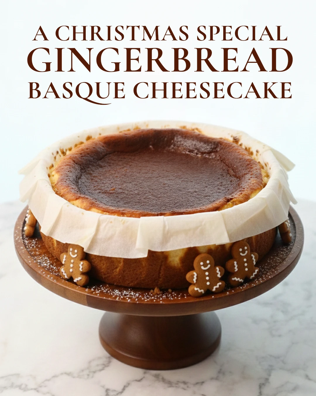 Gingerbread Basque cheesecake, the Christmas special, on a cake stand surrounded by gingerbread men