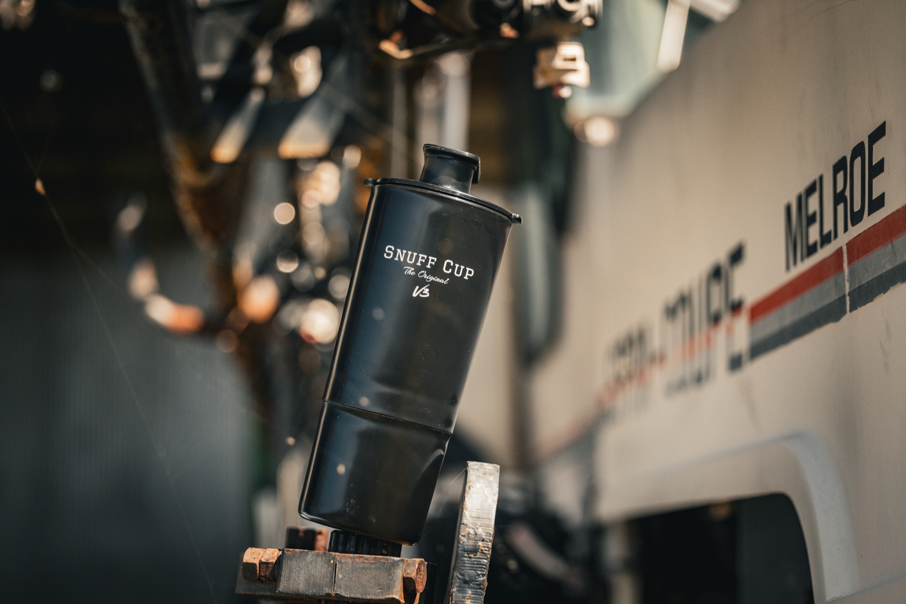 The Snuff Cup Pro V3 spit cup shot on machinery in a workshop